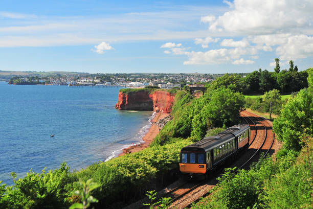 Devon Train A train heading north from Paignton (in the distance) to Torquay. torquay uk stock pictures, royalty-free photos & images