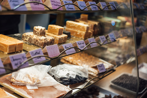 A close-up shot of a display of different flavour fudge in a sweet shop.