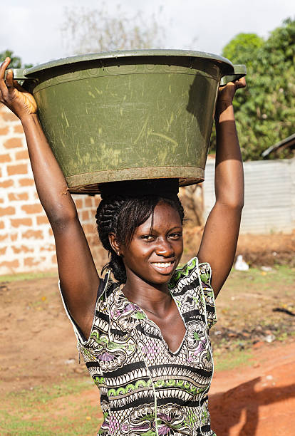 TIKAMGARH, MADHYA PRADESH, INDIA - NOVEMBER 12, 2019: An unidentified indian village woman carry water on their heads in traditional pots from well, An Indian rural scene.