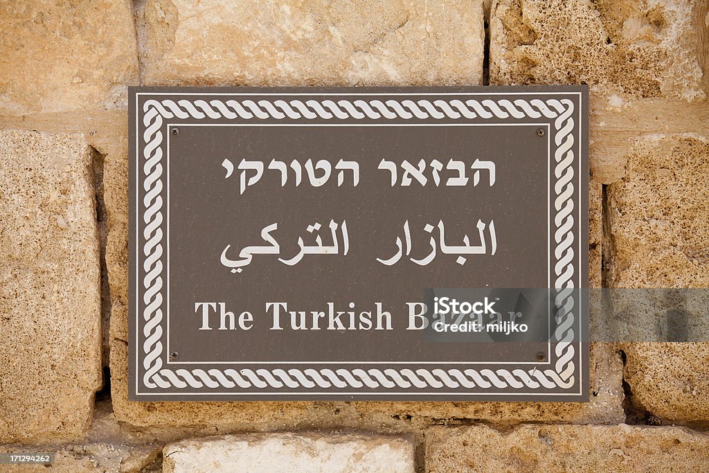 Sign for the Turkish Bazaar "Sign in Hebrew, Arabic, and English, marking the route of the Turkish Bazaar.Photo taken in city of Acco (Acre), Israel" Acco Stock Photo