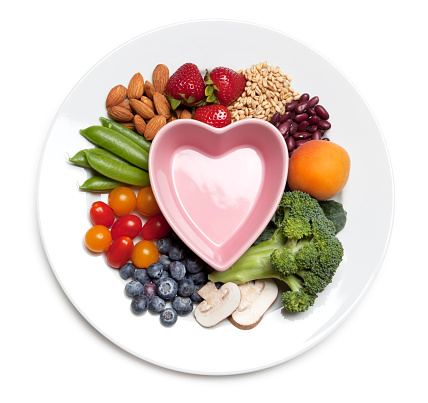 Healthy eating concept with plate of fruits, vegetables, nuts and grains.