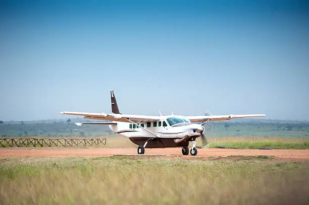 "A Cessna Caravan 208 is starting on the unpaved runway of a bush airstrip in the Masai Mara National Park, Kenya."