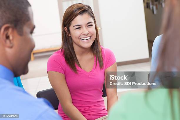 Young Woman Laughing With Friends In A Group Discussion Stock Photo - Download Image Now