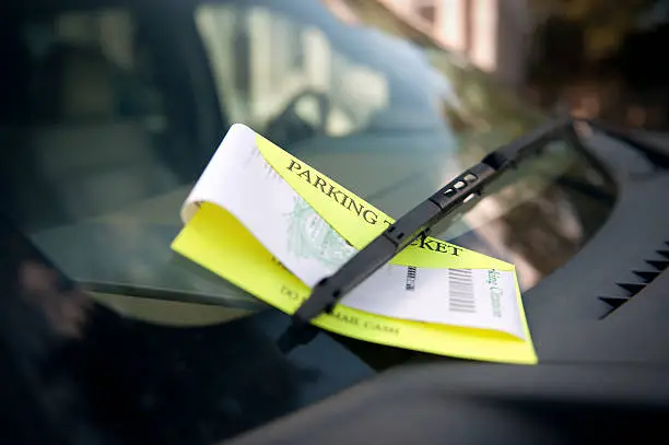 A parking ticket under the wiper blade awaits a future unhappy motorist.
