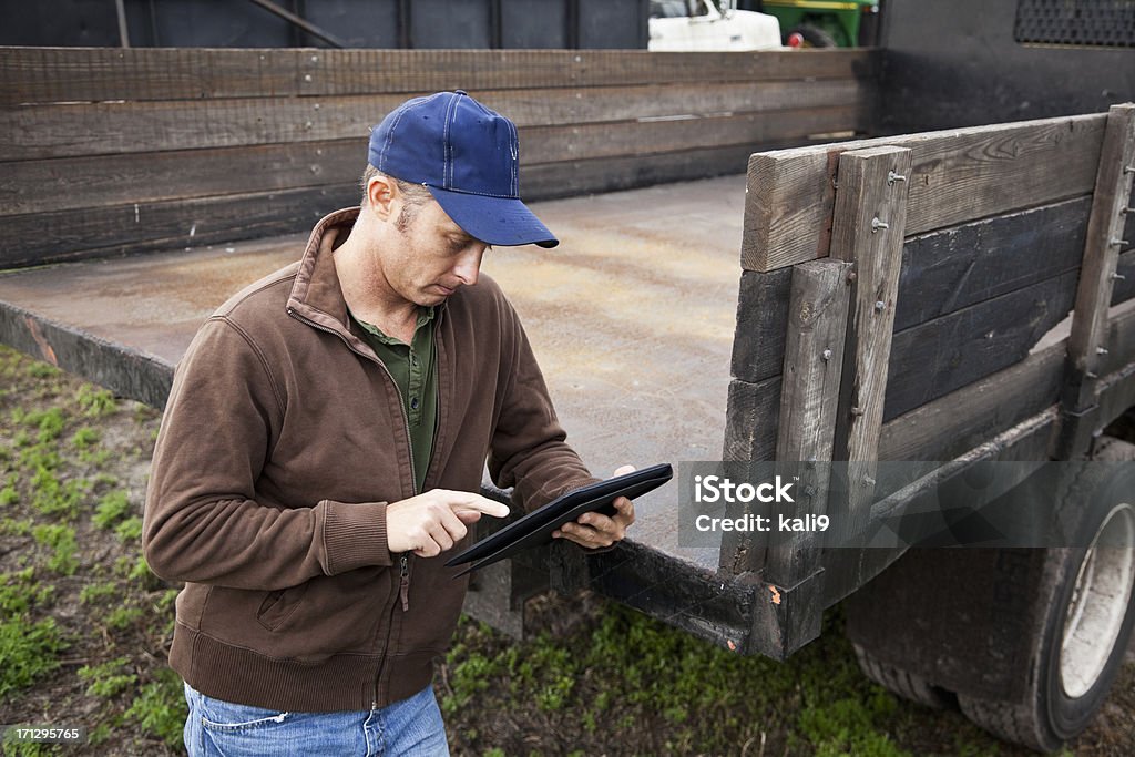 Agricultor usando tablet digital - Foto de stock de Caminhão royalty-free