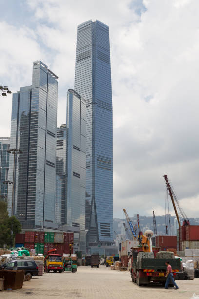 Container terminal in Hong Kong "Hong Kong, China - June 28, 2012: Containers sit in the terminal area of the container port in West Kowloon District, while at the back is International Commerce Centre, the tallest building in Hong Kong. Hong Kong is home to one of the busiest ports in the world. Many workers are working at the terminal area." international commerce center stock pictures, royalty-free photos & images