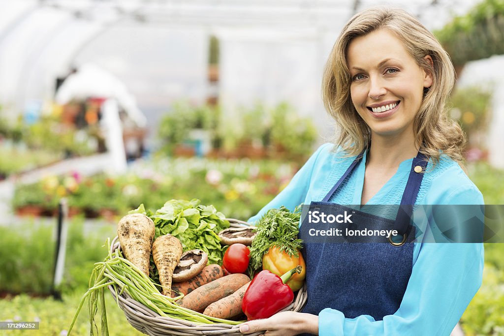 Trabajador mujer sosteniendo cesta de verduras frescas - Foto de stock de Pimiento rojo libre de derechos