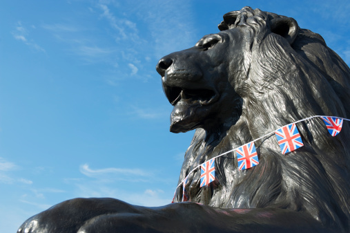 Trafalgar Square lion in London gets dressed up in a collar of celebratory Union Jack bunting on a bright sunny summer day