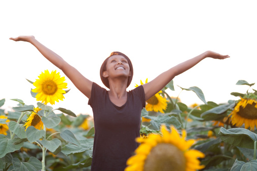A young woman enjoying nature at sunflower field.