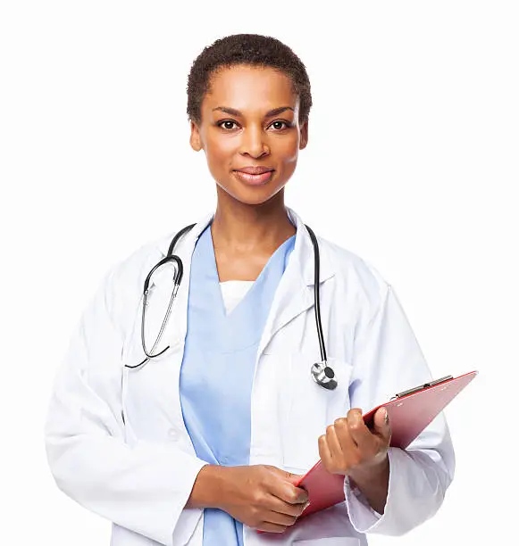 Portrait of a African American female doctor in a lab coat poses with a clipboard in hand. Horizontal shot. Isolated on white.