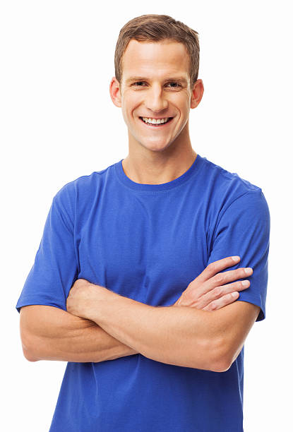 Portrait of a happy young man in a blue t-shirt standing with arms crossed. Vertical shot. Isolated on white.