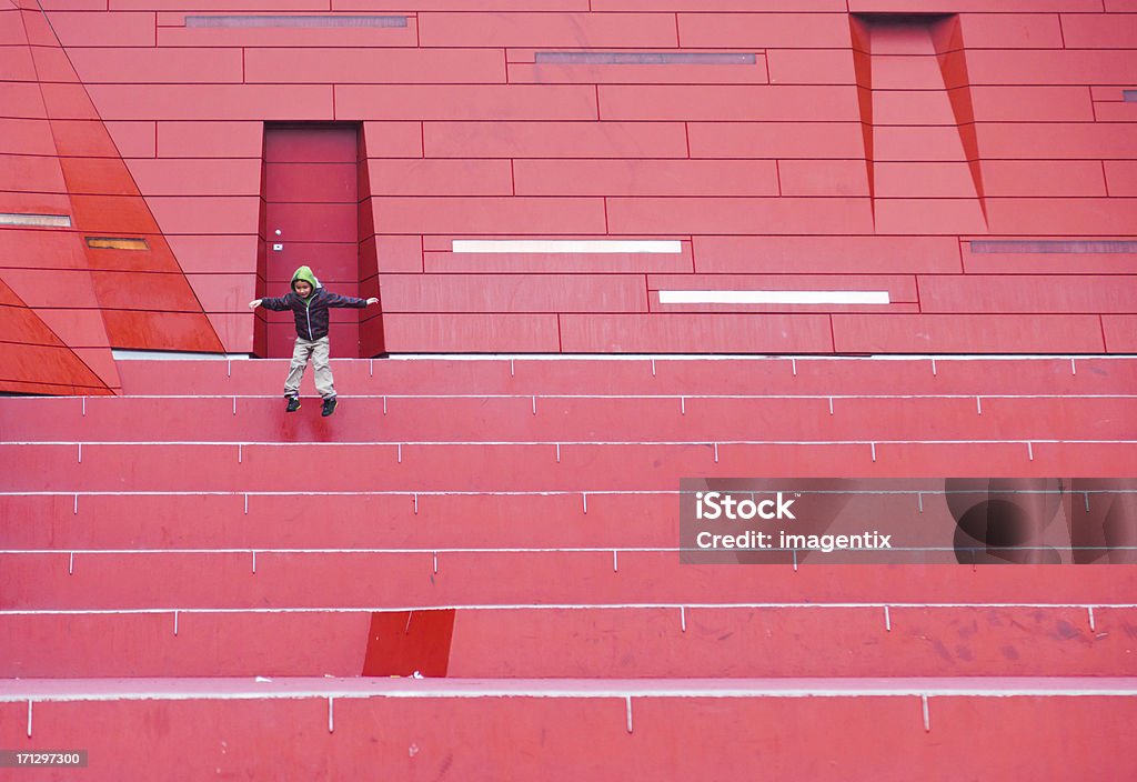 Ragazzo saltando su passi di una struttura Rosso mattone - Foto stock royalty-free di Scalinata