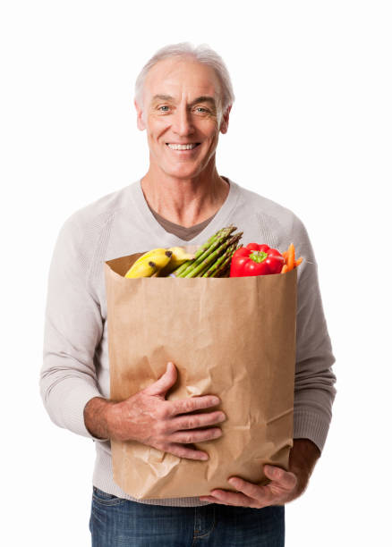 uomo felice con generi alimentari-isolato - senior adult aging process supermarket shopping foto e immagini stock