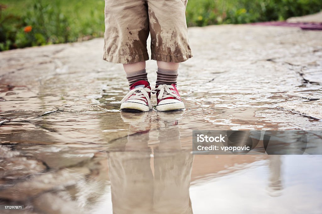 Petit garçon, profitant de la pluie en Flaque - Photo de Mouillé libre de droits