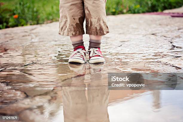 Foto de Menino Aproveitar A Chuva De Verão Na Poça e mais fotos de stock de Molhado - Molhado, Calça Comprida, Calça corsário