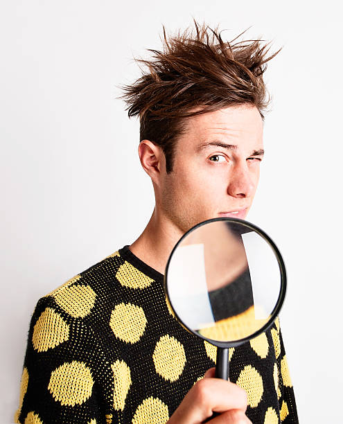 istock Young man examining something suspiciously through mangifying glass 171298615