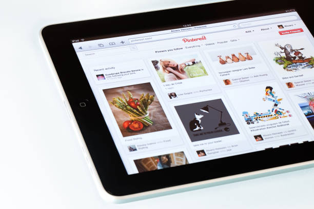 Pinterest page on  Apple iPad2 "Montevideo, Uruguay - March 15, 2012: Highangle view of an Apple iPad2 displaying Pinterest homepage on a desk. Pinterest is a pinboard-style social photo sharing website that allows users to create and manage theme-based image collections. iPad, the digital tablet with multi touch screen produced by Apple Computer, Inc." homepage photos stock pictures, royalty-free photos & images