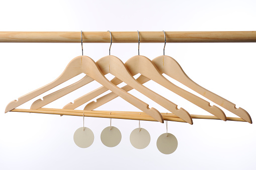 Wooden coat hanger with blank tag isolated on white background.