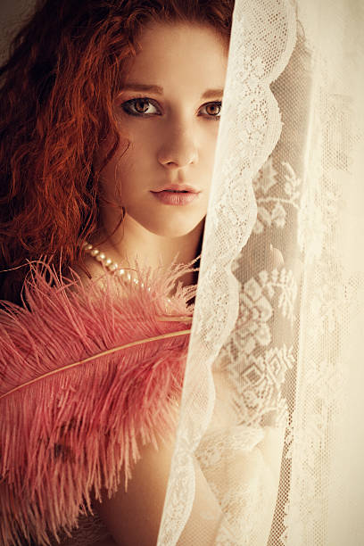 istock young girl with feather fan by the window 171299161
