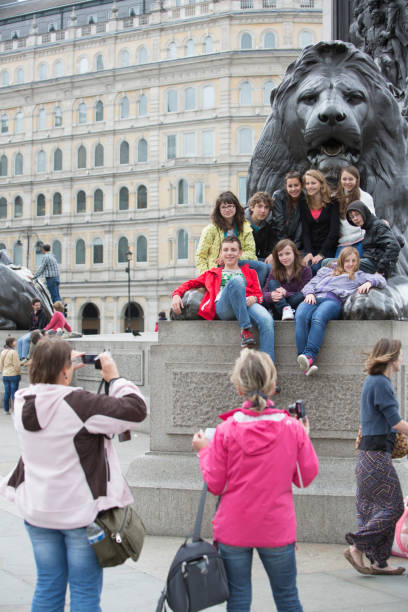 turisti con trafalgar square, leoni - lion statue london england trafalgar square foto e immagini stock