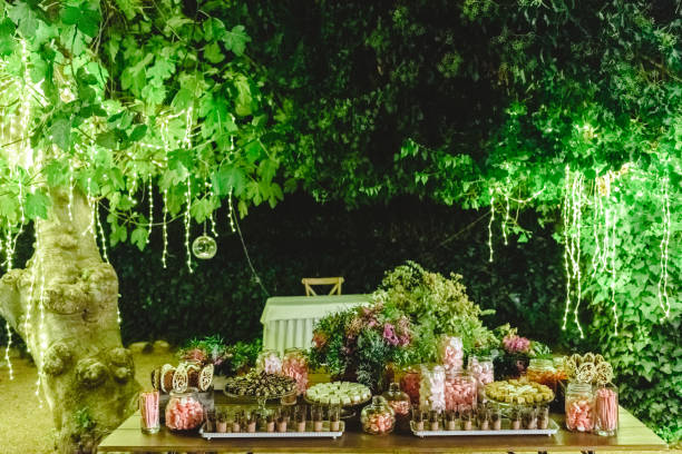 istock Table with sweet desserts in a garden at night, illuminated by LED lights. 1712992930
