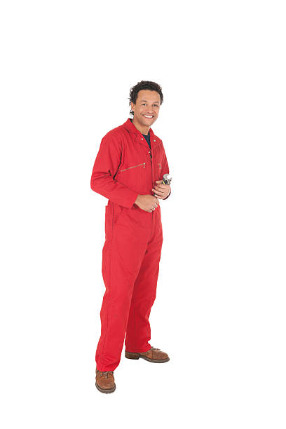 Happy Mechanic In Red Overalls - Isolated. Full length portrait of happy mechanic in red overalls holding wrench. Isolated on white. jumpsuit stock pictures, royalty-free photos & images