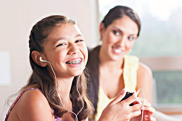 Young girl listening to music with mother behind herPlease see similar images in my portfolio: