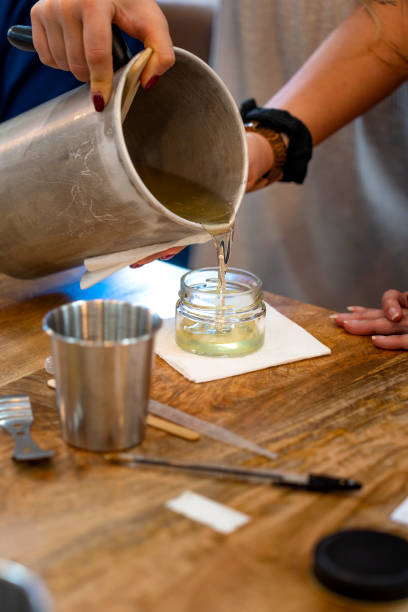 istock Aromatic candle workshop. Woman pouring melted soy wax. 1713008368