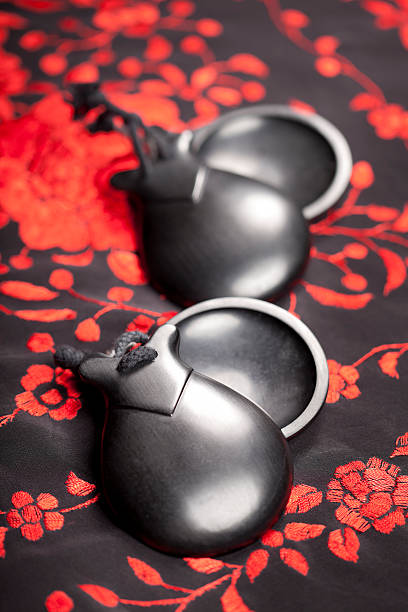 Flamenco castanets Black wood castanets (typical flamenco instrument) over embroidered red/black shawl. castanets stock pictures, royalty-free photos & images