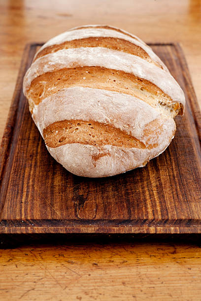 appena sfornati, pane fatto in casa in legno chopping bordo - whole wheat flour foto e immagini stock