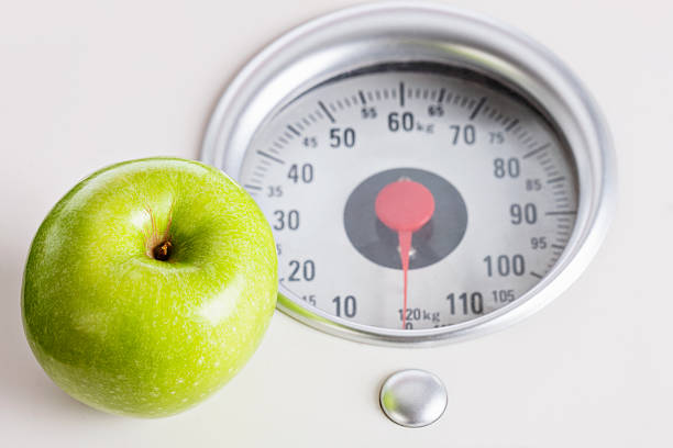 istock Green apple on scale: watching your weight means eating properly 171301551