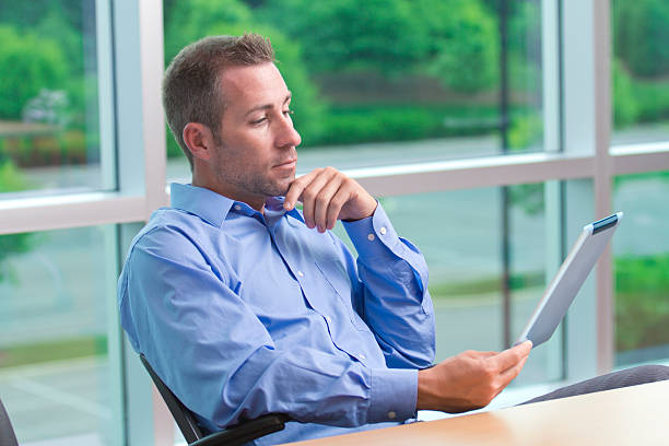 istock Businessman relaxing in his office reading from a digital tablet 171302047
