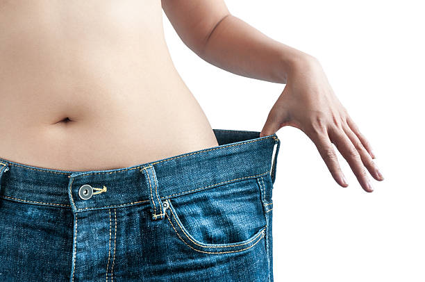 dieta mulher demonstrando a perda de peso - torso women jeans abdomen imagens e fotografias de stock