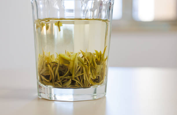 una taza de vidrio de té verde - tea tea leaves jasmine tea leaf fotografías e imágenes de stock