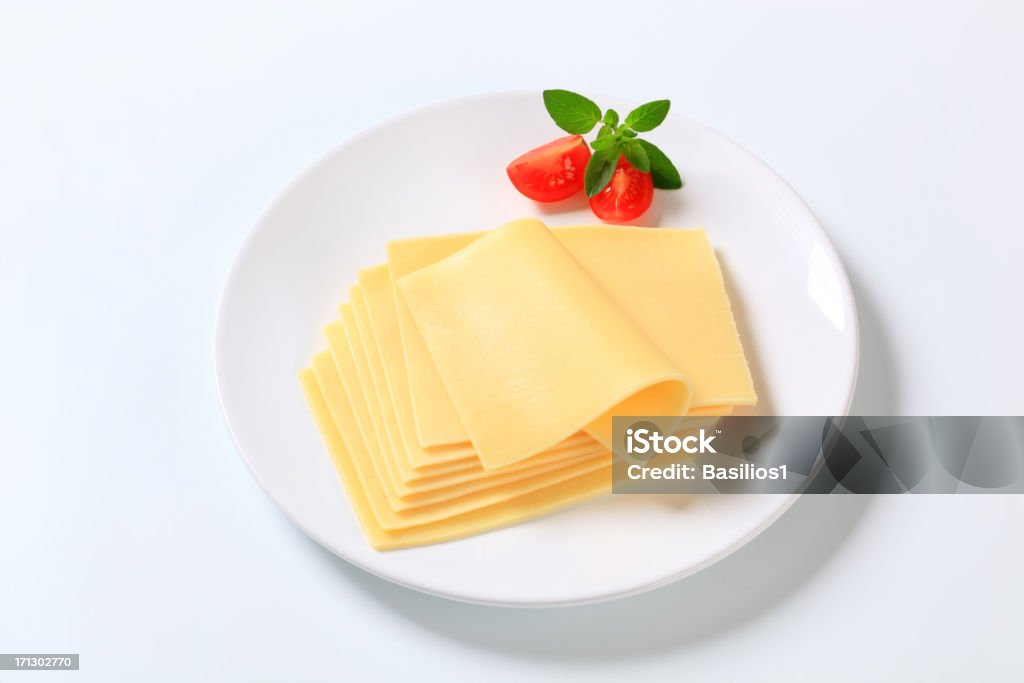 sliced cheese thin slices of a fresh cheese on a white plate Basil Stock Photo