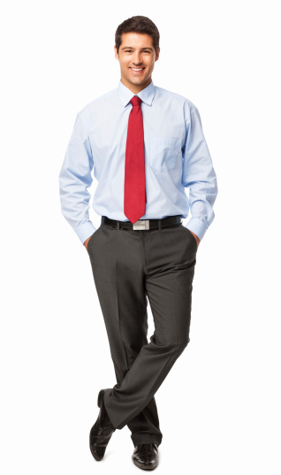 Full length portrait of a happy businessman standing with hands in pockets. Vertical shot. Isolated on white.