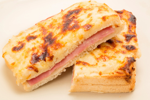Classic French toasted sandwich or Croque monsieur cut in half and placed on a plate - studio shot