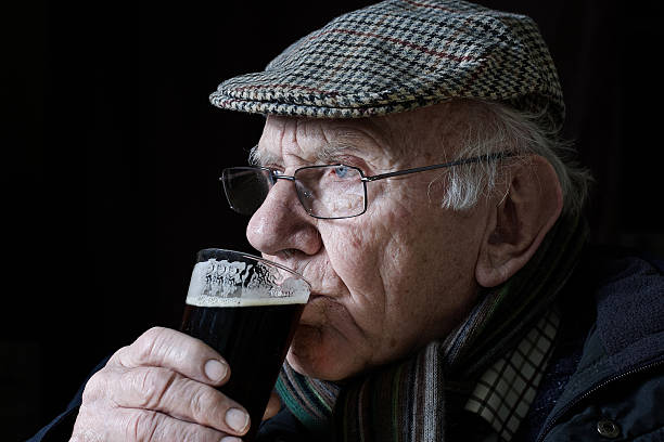 Octogenarian drinking glass of beer Octogenarian drinking glass of beer flat cap stock pictures, royalty-free photos & images