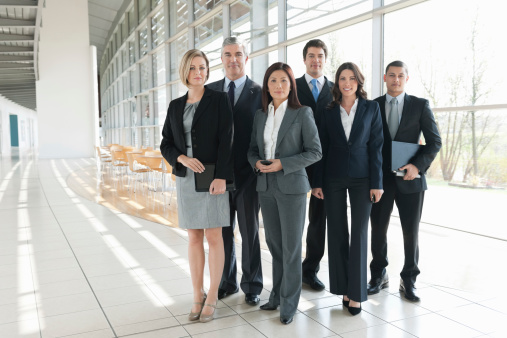 Full length portrait of confident multiethnic business team standing together in board room. Horizontal shot.