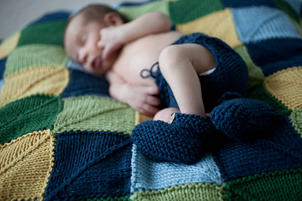 istock Newborn baby with blue knitted booties 171303655