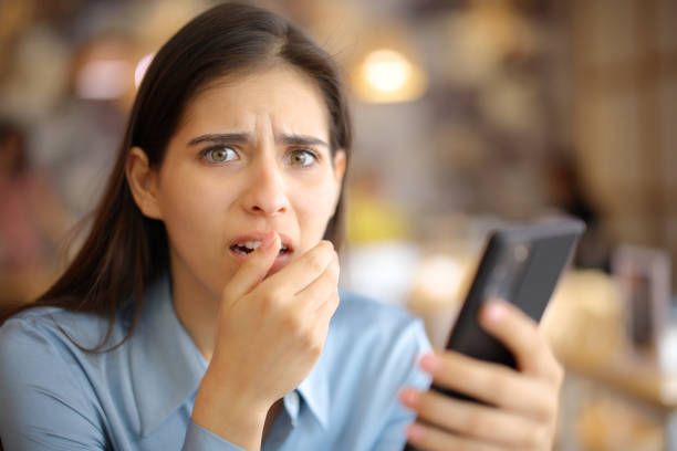 istock Terrified woman holding phone in a bar 1713037678