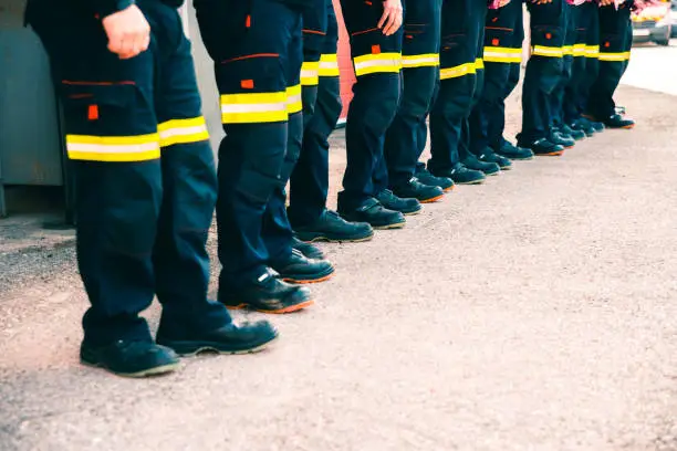 Group of firefighters doing teamwork dressed in their work uniforms.