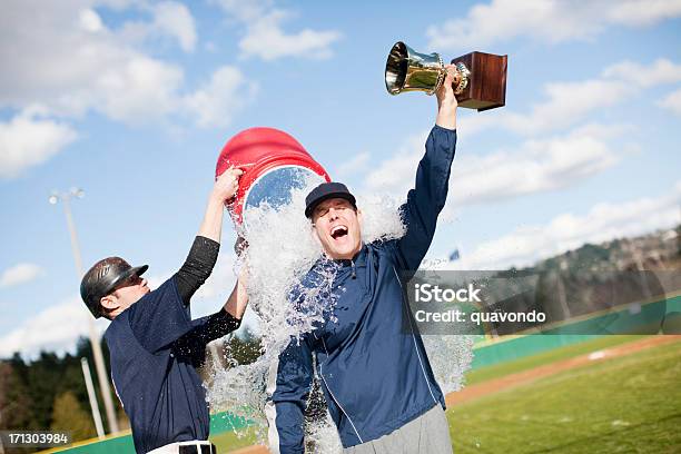 Player Dumping Gatorade On Coach Holding A Trophy Stock Photo - Download Image Now - Winning, Coach, Baseball - Sport