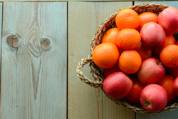 istock Fruit basket on a wooden table. Oranges and apples in a wicker basket 1713040539