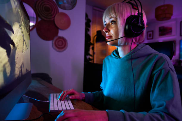istock Young caucasian woman playing game at night on Desktop PC 1713041723