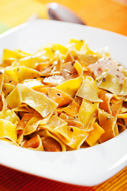 Parpadele with cream and herbs Parpadele with cream and herbs; parpadele is type of italian pasta which is like tagliatelle cooked selective focus vertical pasta stock pictures, royalty-free photos & images