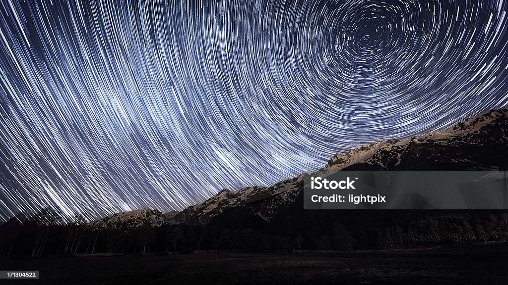 Full of stars Startrails around Polaris in the north over alpine mountain scenery (Salfeins Tirol).100 stacked pictures.Attention: High ISO nightshots (ISO 1600/ Canon 5D Mark II/ EF 16-35 mm f2.8 L) during a moonless night. Due to this technique there is some noise! Astronomy Stock Photo