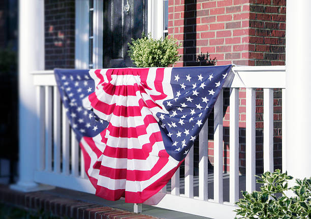 American flag bunting on a house's white railing. Patriotic Bunting Decorations are hung on the front porch for the upcoming elections or celebration of Independence Day. american flag bunting stock pictures, royalty-free photos & images