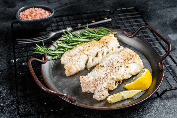 istock Roast Fillets of codfish, cooked cod fish meat. Black background. Top view 1713046222