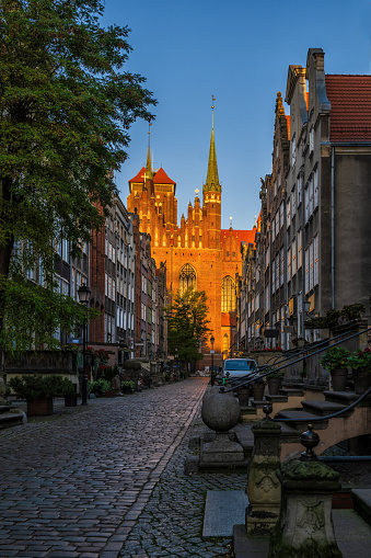 Mariacka Street and Church of St. Mary at sunrise in city of Gdansk in Poland. Landmark street in the Old Town, established around 14th century with historic burgher houses and view towards Gothic Basilica of Saint Mary.